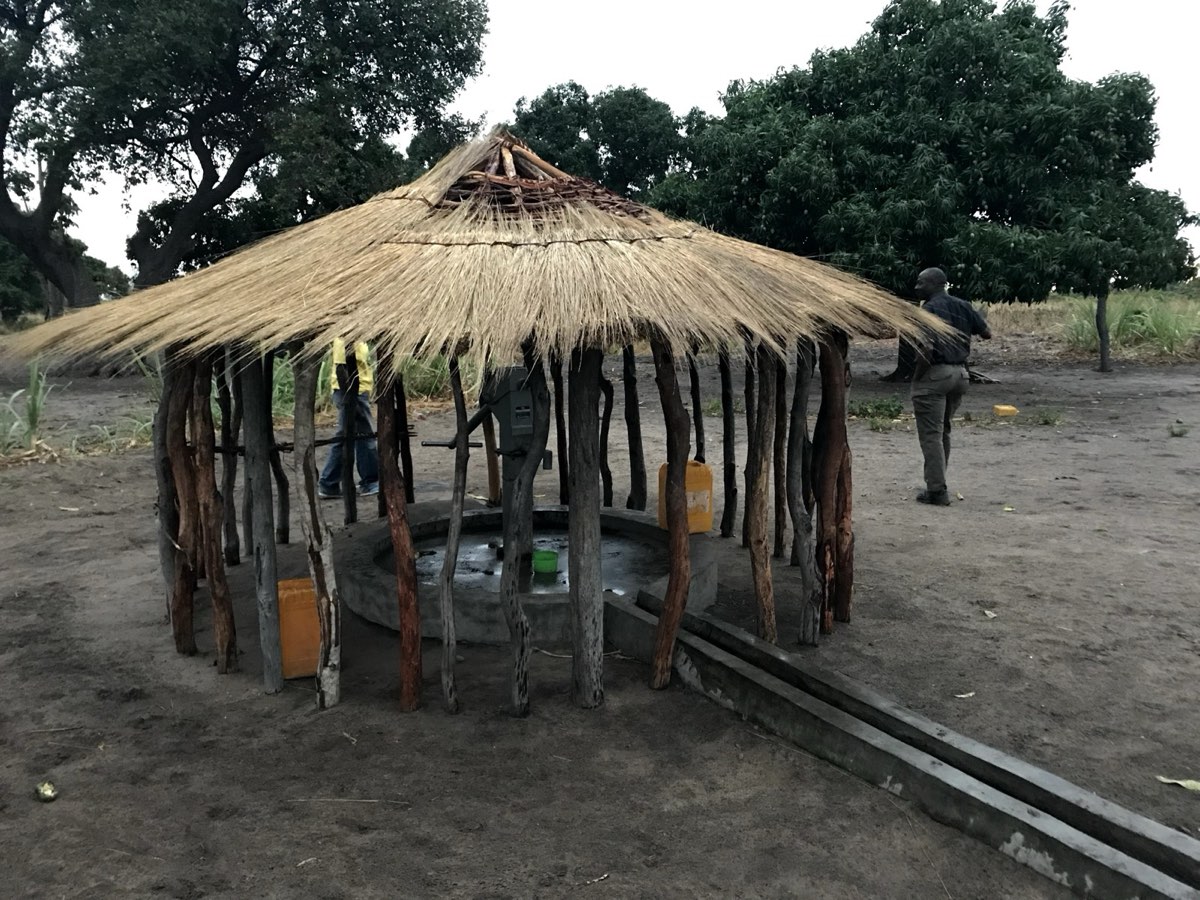 A completed borehole under a thatched shelter