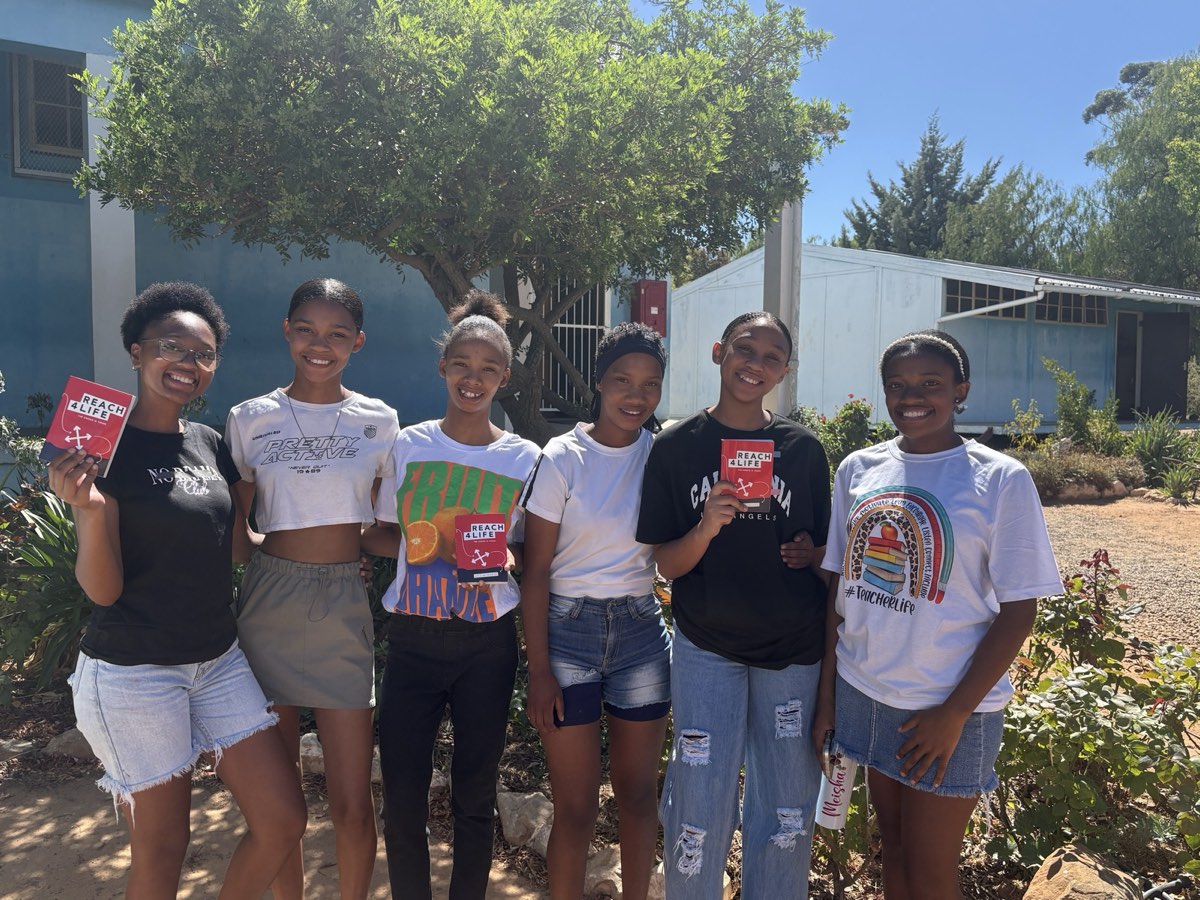 Learners holding Reach4Life Bibles